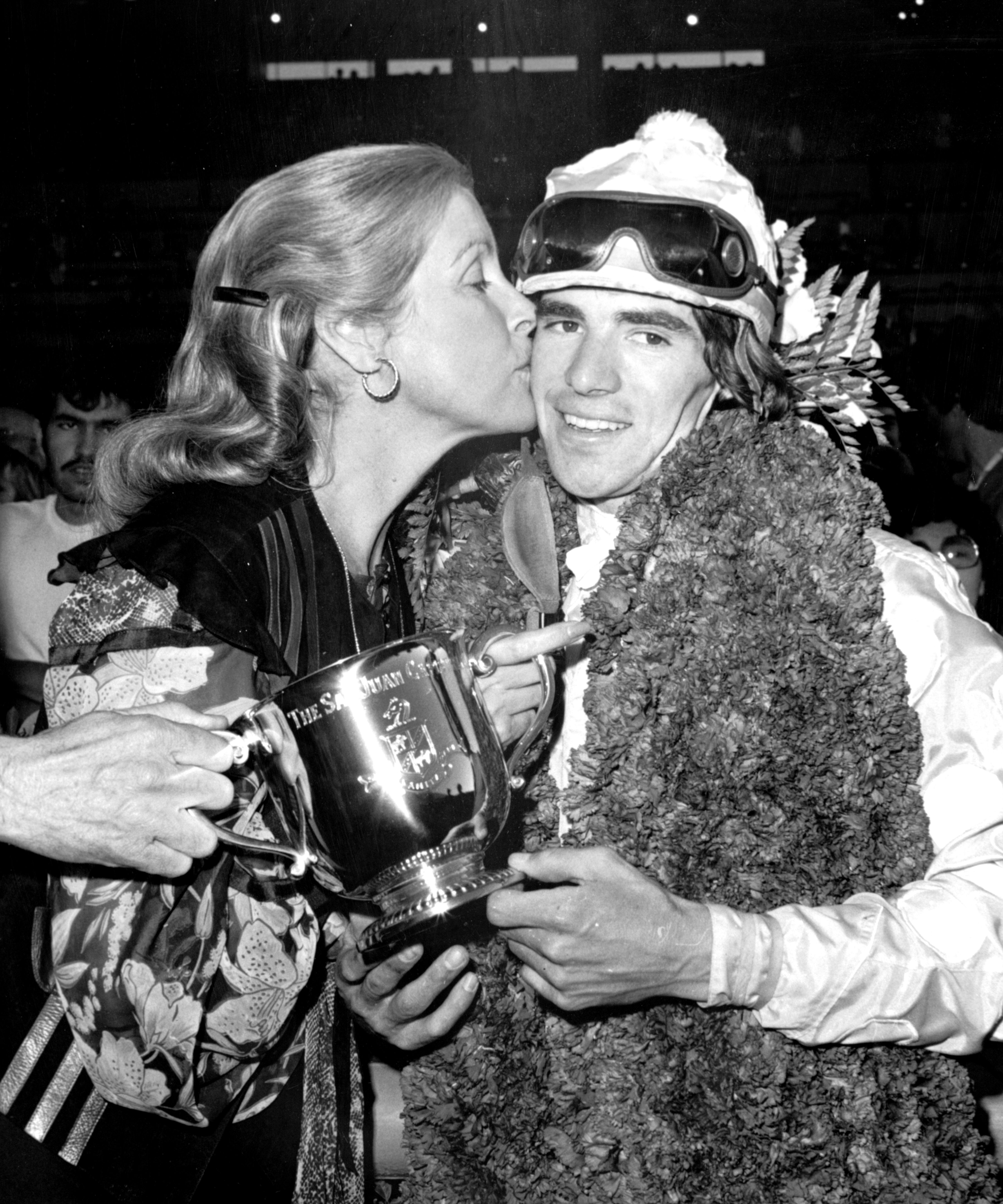 Darrel McHargue receives a kiss from Jacqueline Getty after winning the 1977 San Juan Capistrano Handicap (Keeneland Library Thoroughbred Times Collection)