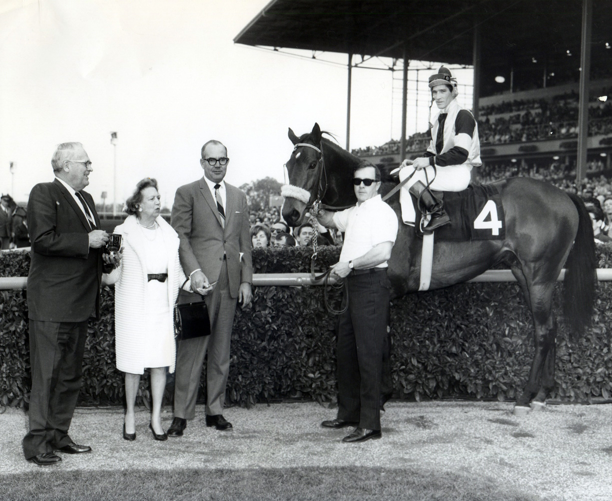 Owner Elizabeth Arden Graham and trainer Eddie Neloy join Gun Bow (Manuel Ycaza up) in the winner's circle for the 1965 San Antonio Handicap at Santa Anita (Santa Anita Photo/Museum Collection)